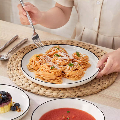 MINA porcelain dinnerware set featuring curved-edge plates and bowls with lifted rims#color_black-trim