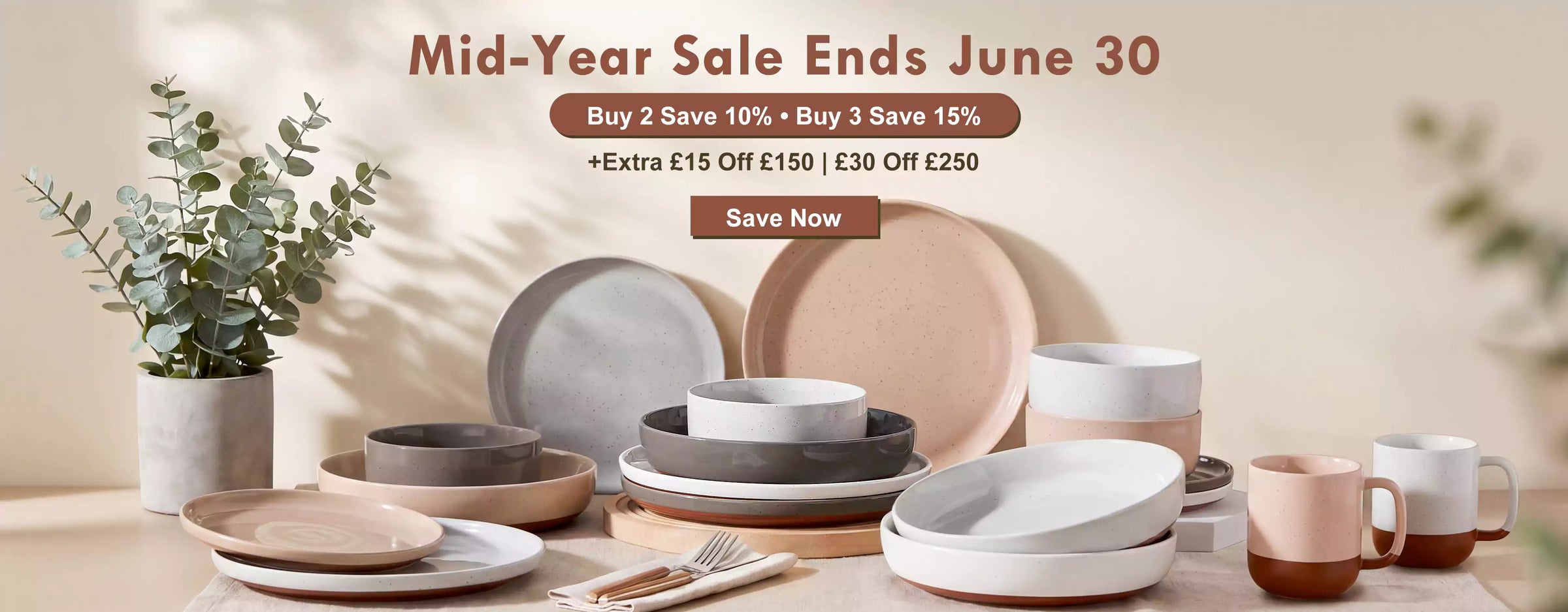 Dining table with ceramic plates and bowls, promotional text for a mid-year sale.